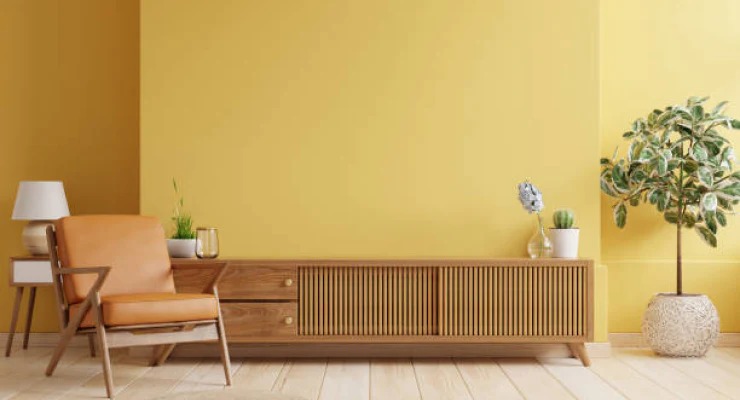 Modern living room with yellow walls, wooden furniture, and decorative plants.